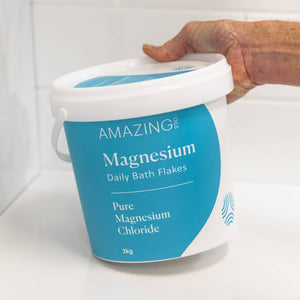 Magnesium flakes 2kg hand holding the tub